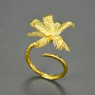 Gold palm tree ring on a gray background