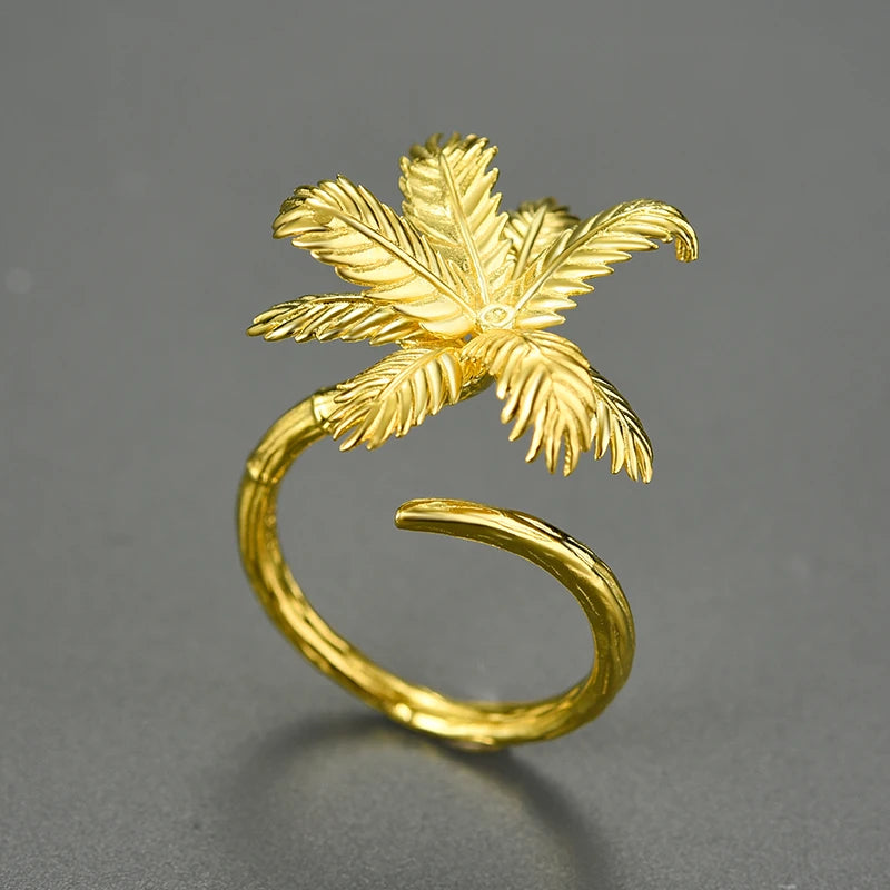 Gold palm tree ring on a gray background